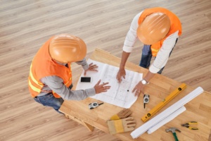 discussing blueprint 300x200 - 5 Ways to Manage Construction Project Budget